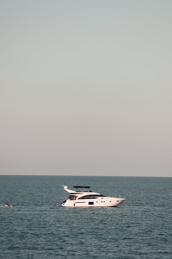 Elegant yacht cruising on the serene ocean under a clear sky, perfect for travel and leisure.