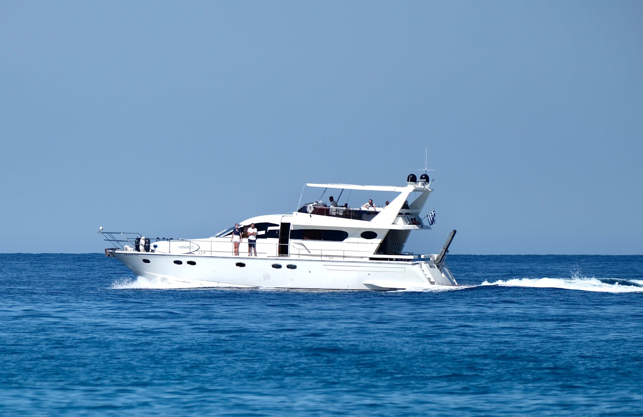 A sleek white yacht cruising in the blue sea near Parga, Greece.