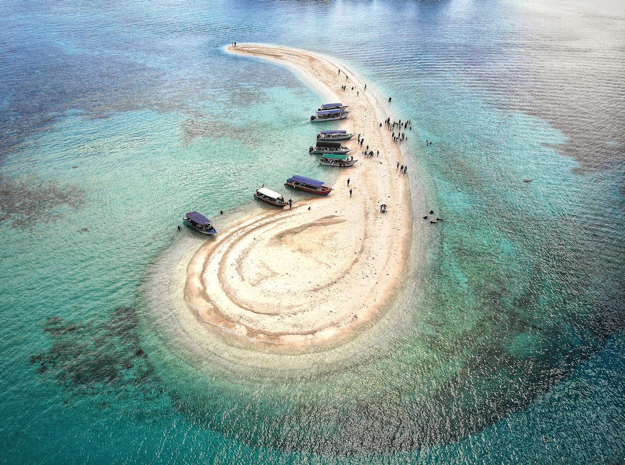Stunning aerial view of a sandbar in Kuala Terengganu, Malaysia, with boats and clear turquoise water.